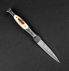 Decorative knife with a detailed blade on a black background