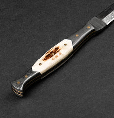 Handmade knife with a decorative handle on a dark background