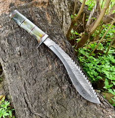 Damascus kukri knife with camel bone handle lying on a tree