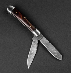 Folding knife with wooden handle on a dark gray background