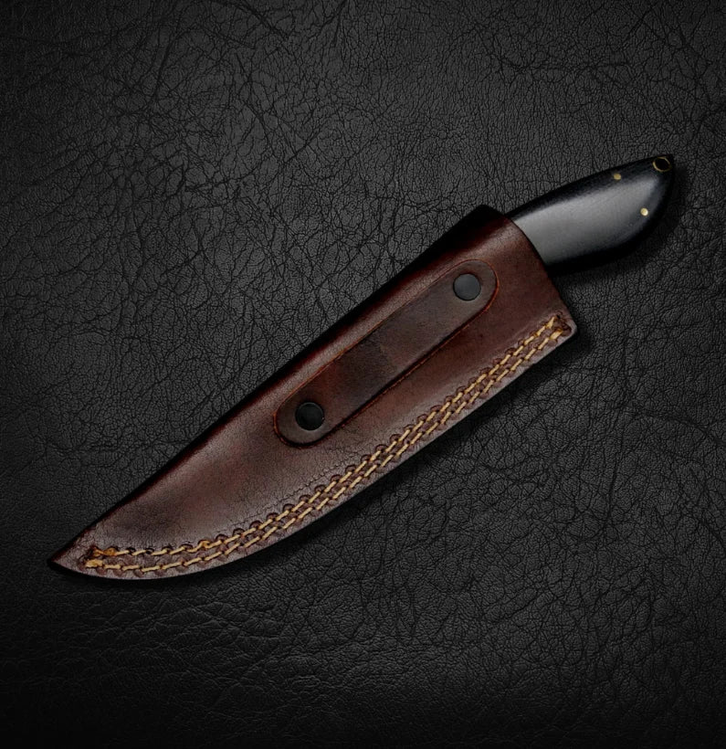 Knife with a brown leather sheath on a dark textured background
